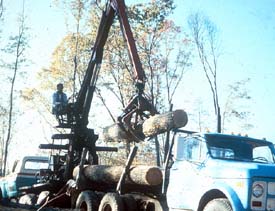 Knuckle boom unloading logs from log truck Knuckle boom unloading logs from log truck